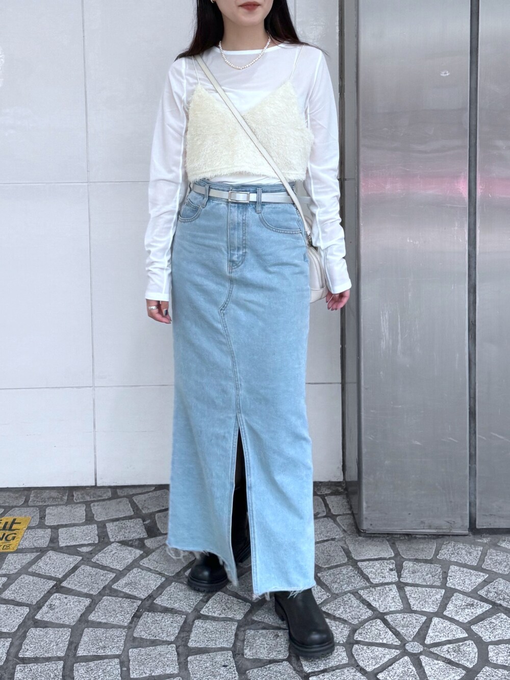 ブルー系のデニムスカート、ブラック系のブーツ、ホワイト系のキャミソールを着用したレディースの夏コーディネートの3枚目の写真