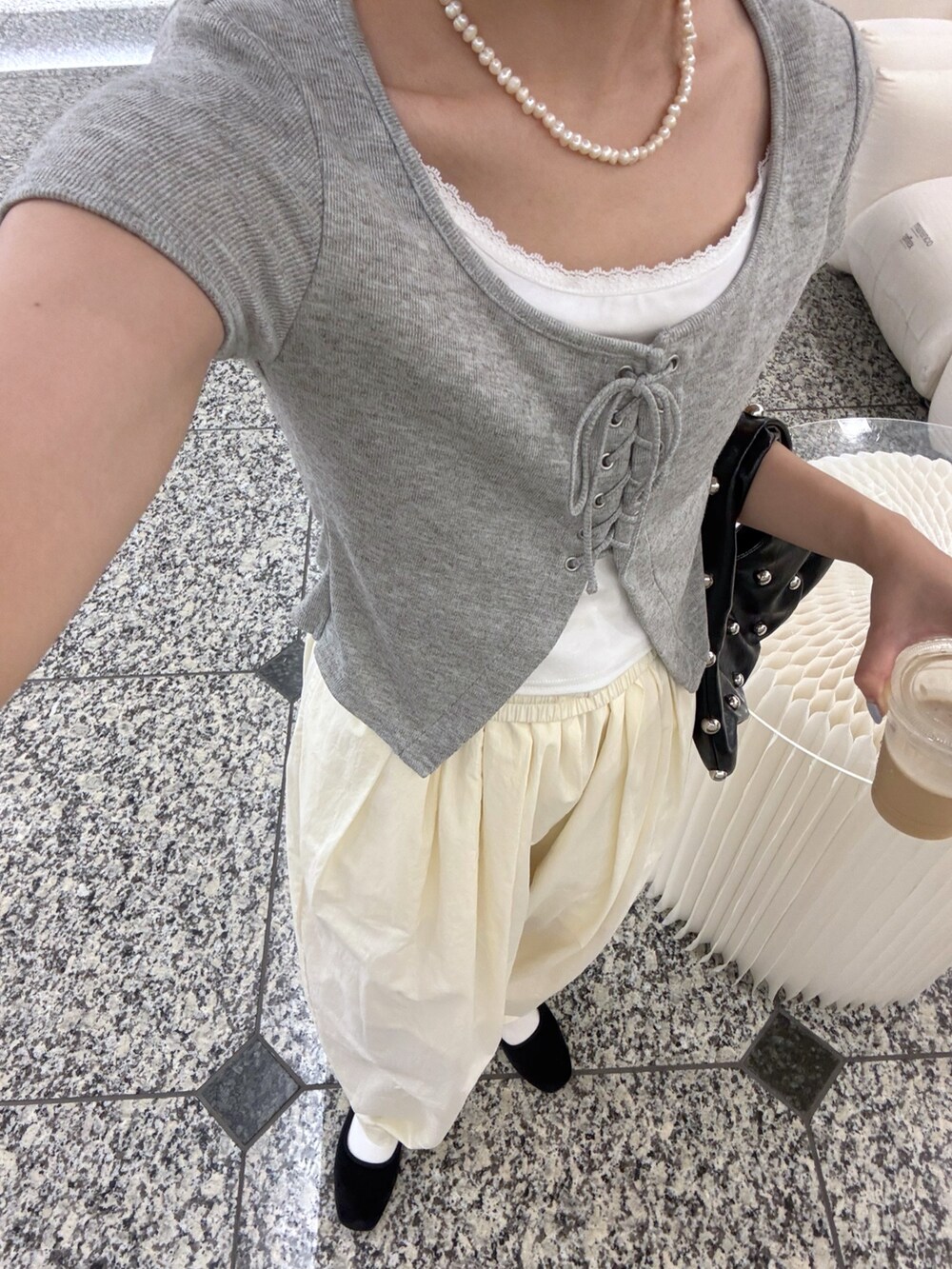 グレー系のTシャツ/カットソー、ブラック系のハンドバッグを着用したレディースの夏コーディネートの2枚目の写真