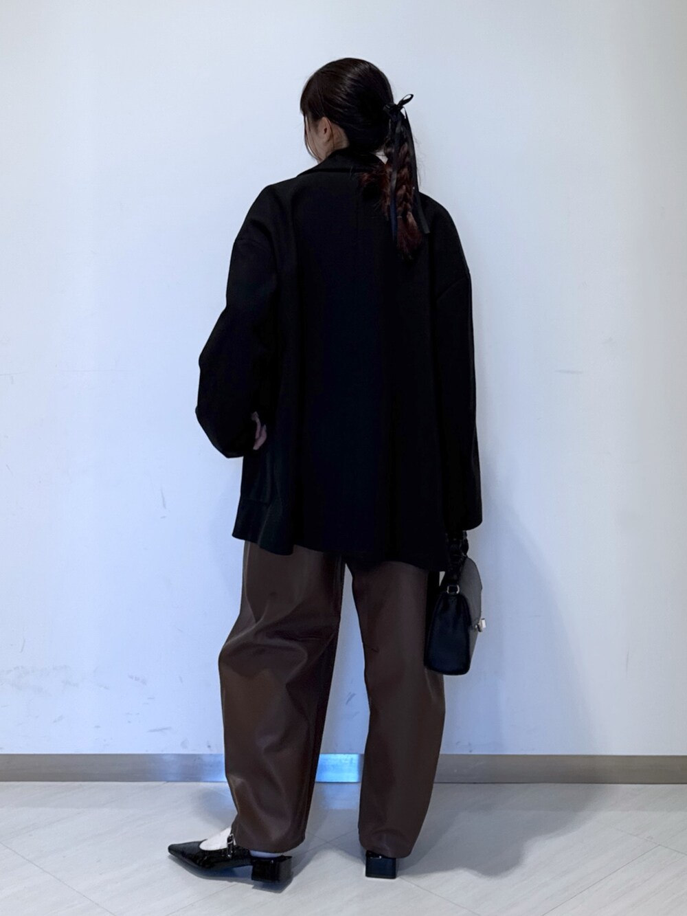 ブラック系のパンプス、ブラック系のショルダーバッグ、ホワイト系のニット/セーターを着用したレディースの秋コーディネートの4枚目の写真