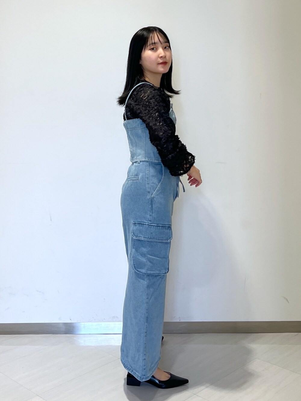 ブラック系のシャツ/ブラウス、ブルー系のベスト、ブルー系のデニムスカートを着用したレディースの冬コーディネートの4枚目の写真