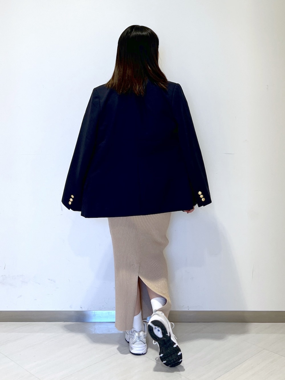 ホワイト系のTシャツ/カットソー、ブルー系のテーラードジャケット、ゴールド系のスカートを着用したレディースの冬コーディネートの5枚目の写真