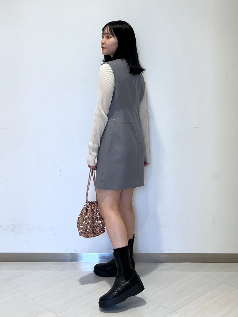 ホワイト系のニット/セーター、グレー系のワンピース、ピンク系のハンドバッグを着用したレディースの春コーディネートの2枚目の写真