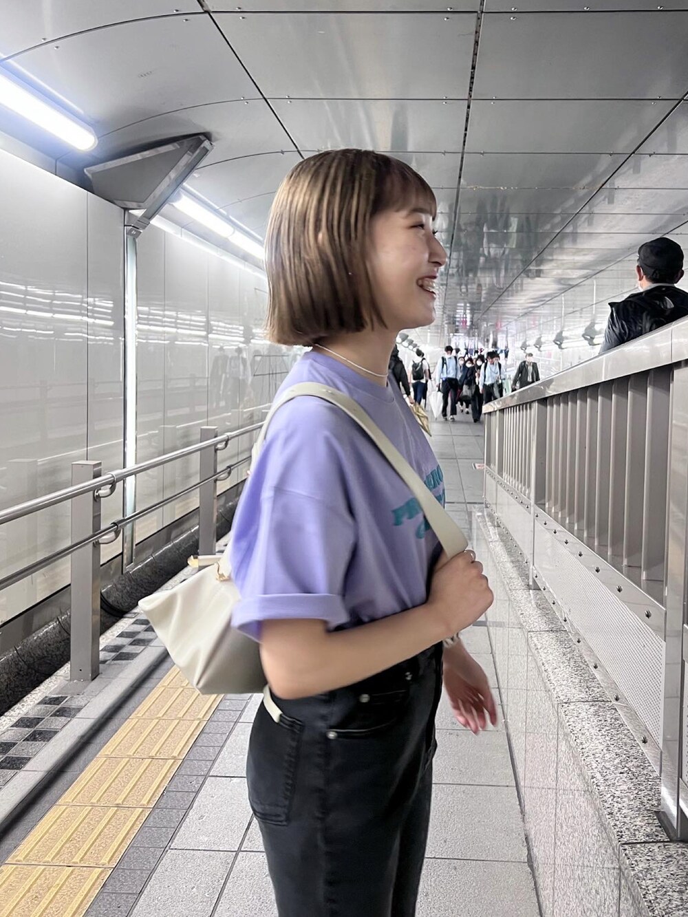 ブラック系のデニムパンツ、パープル系のTシャツ/カットソー、ホワイト系のボディバッグ/ウエストポーチを着用したレディースの春コーディネートの4枚目の写真