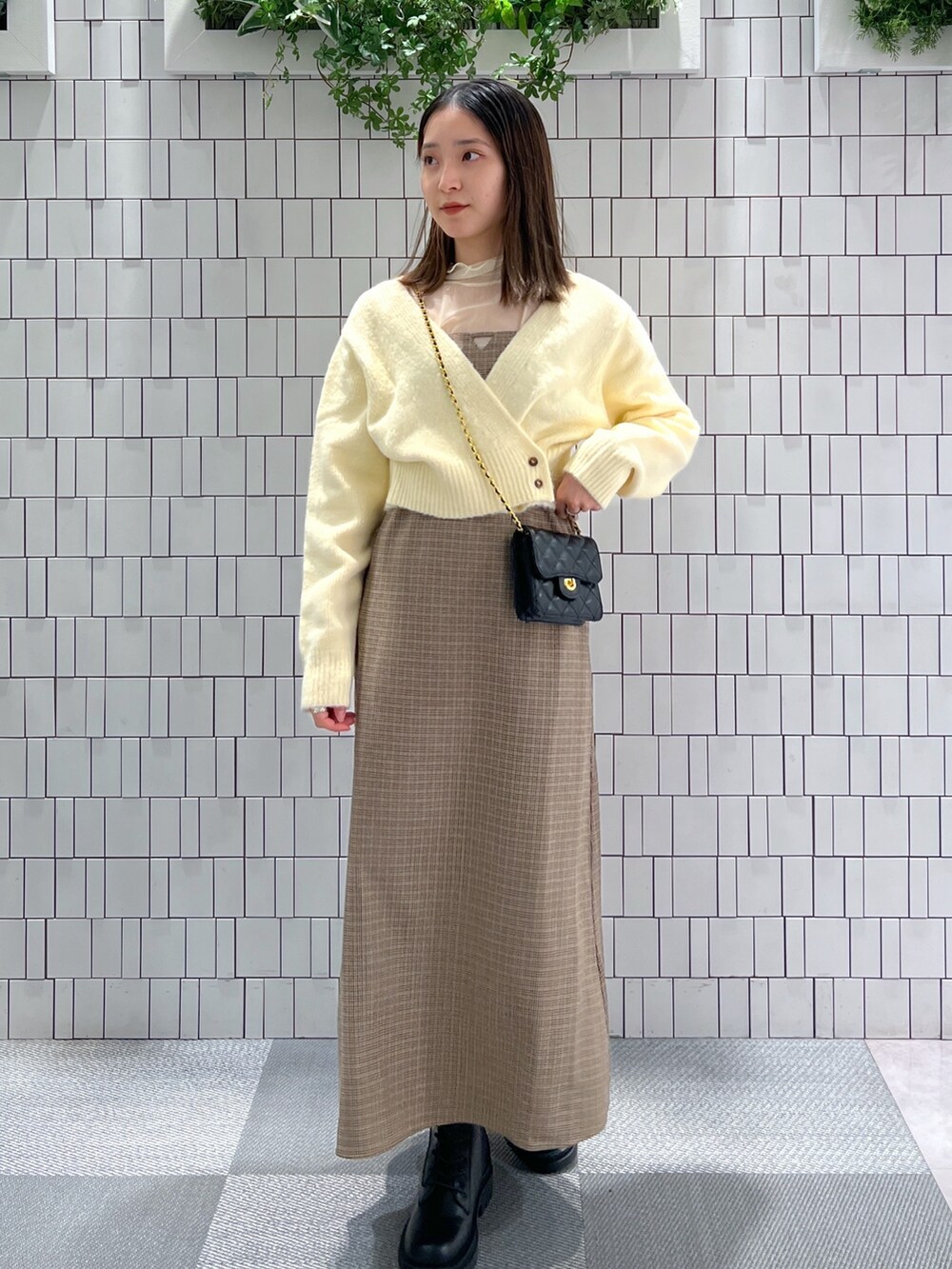 ホワイト系のニット/セーター、ホワイト系のTシャツ/カットソー、ブラウン系のワンピースを着用したレディースの冬コーディネートの3枚目の写真