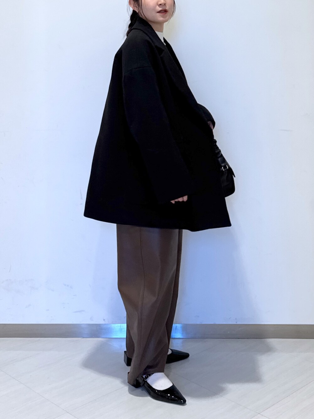 ブラック系のパンプス、ブラック系のショルダーバッグ、ホワイト系のニット/セーターを着用したレディースの秋コーディネートの3枚目の写真