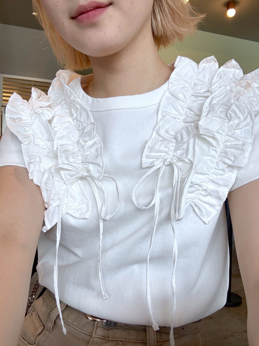 ホワイト系のTシャツ/カットソー、ベージュ系のその他パンツ、ブラック系のショルダーバッグを着用したレディースの春コーディネートの3枚目の写真