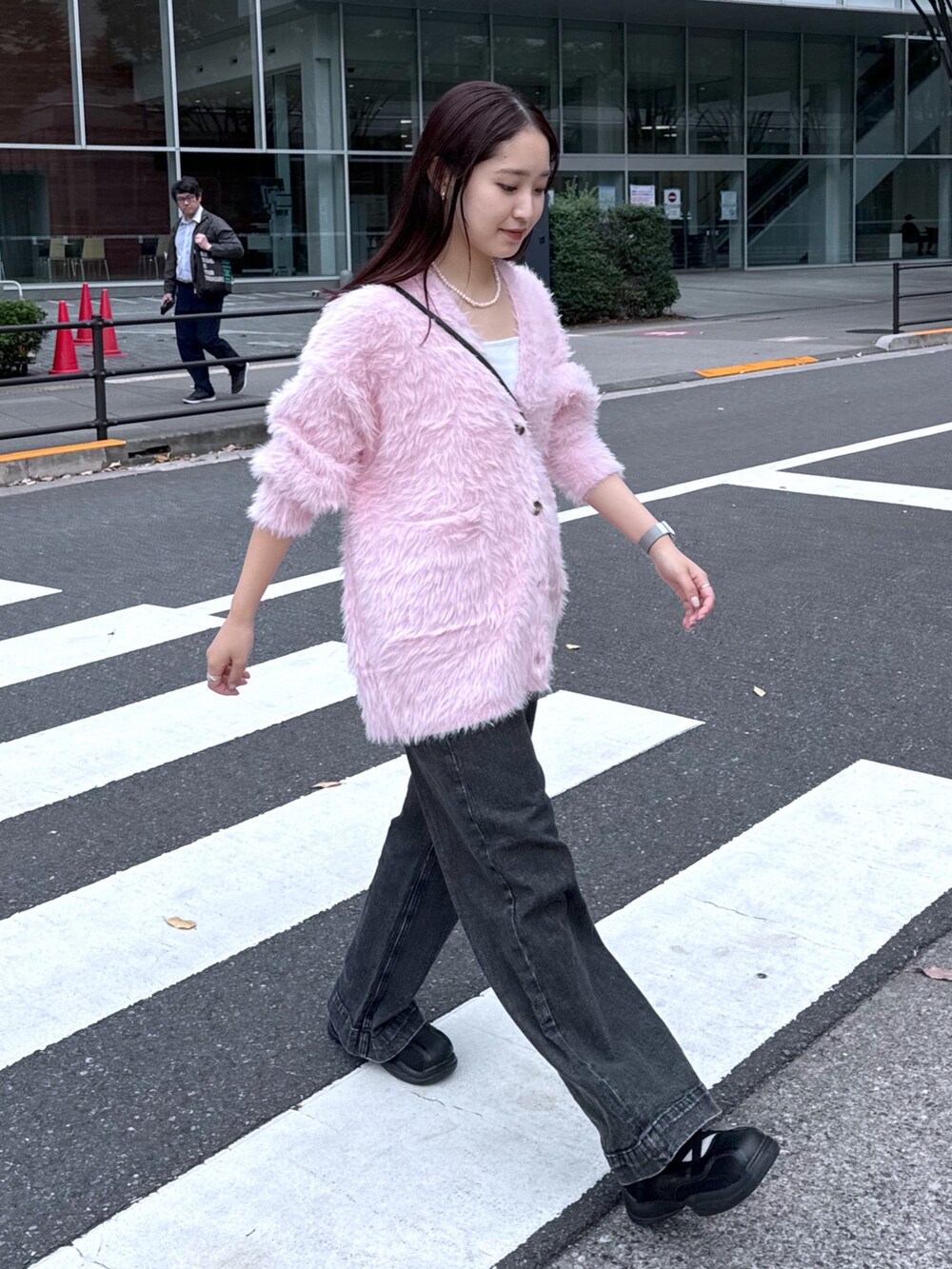 ブラック系のデニムパンツ、ピンク系のカーディガン/ボレロ、ホワイト系のキャミソールを着用したレディースの秋コーディネートの2枚目の写真