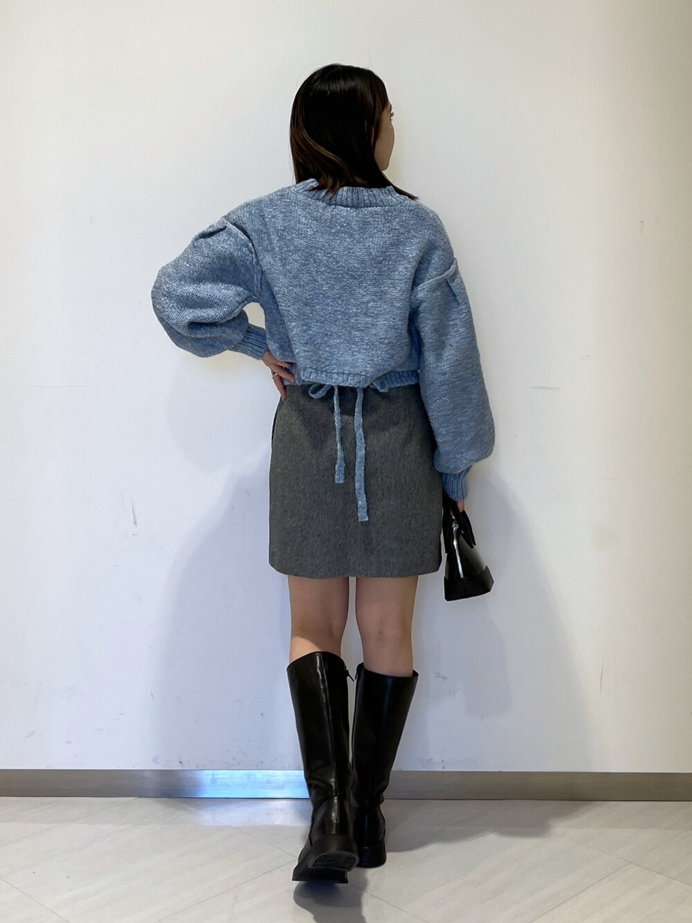 ブラック系のMA-1、ブルー系のニット/セーター、ブラック系のスカートを着用したレディースの冬コーディネートの6枚目の写真