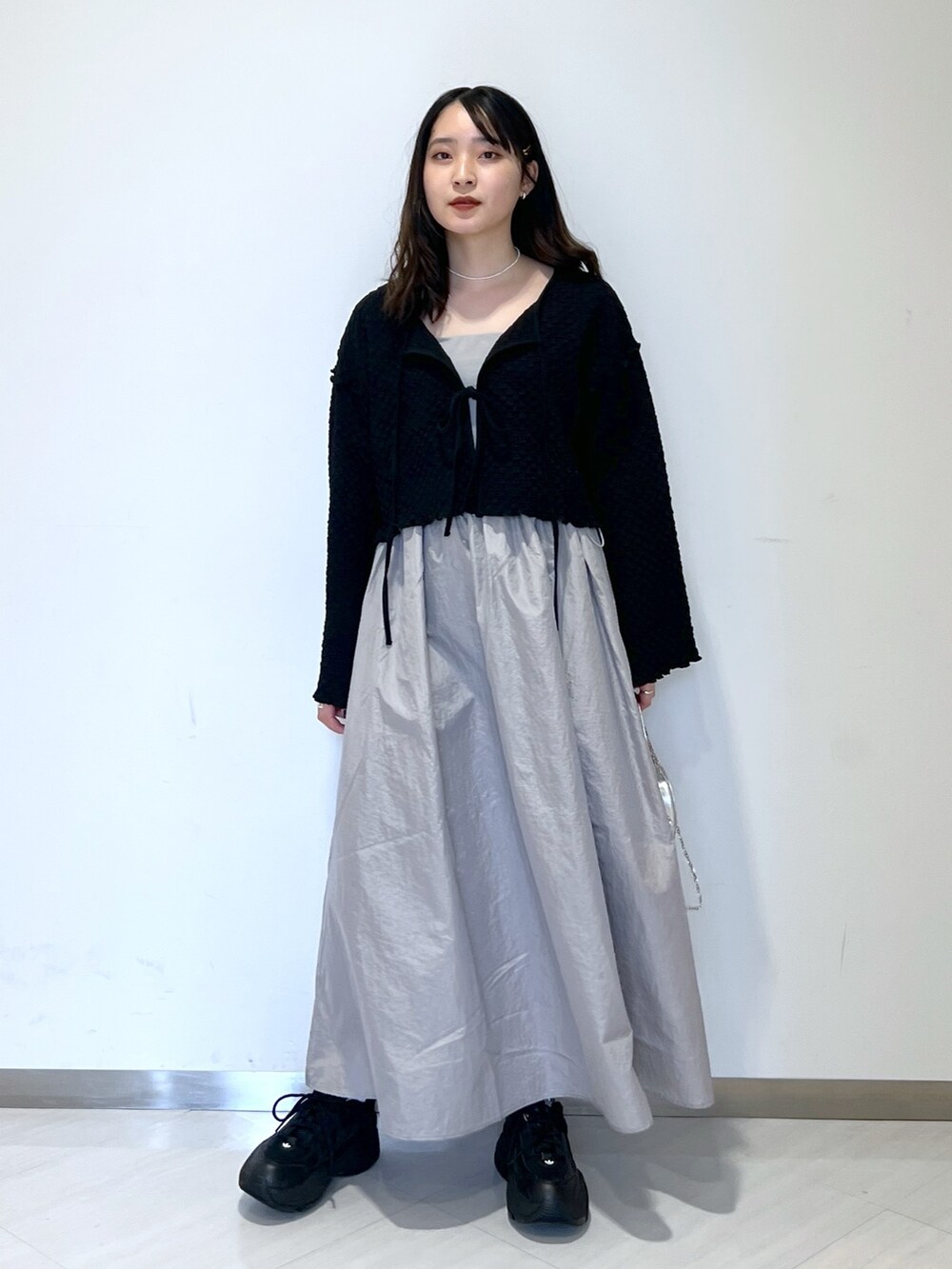 ブラック系のカーディガン/ボレロ、グレー系のワンピース、シルバー系のショルダーバッグを着用したレディースの春コーディネートの3枚目の写真