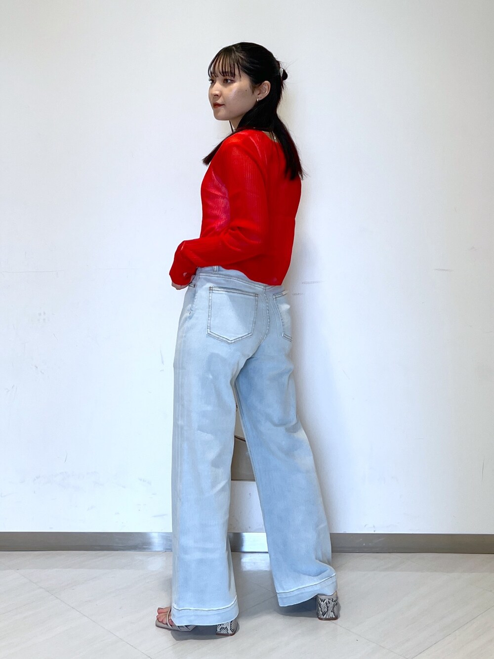 ブルー系のデニムパンツ、ベージュ系のトートバッグ、グレー系のサンダルを着用したレディースの夏コーディネートの5枚目の写真