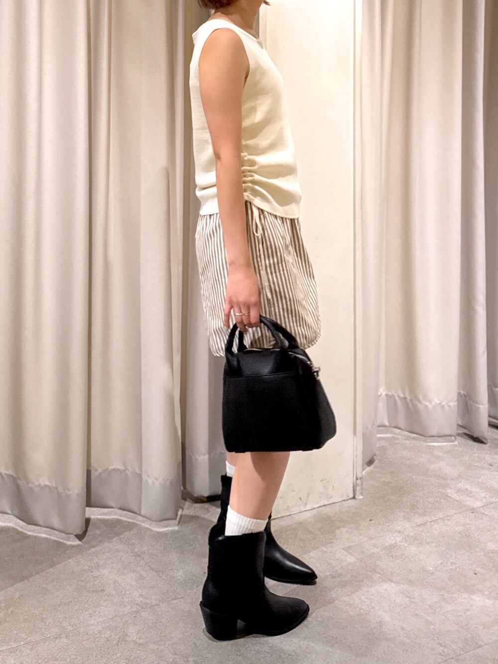 ブラウン系のその他パンツ、ホワイト系のニット/セーター、ブラック系のトートバッグを着用したレディースの夏コーディネートの4枚目の写真