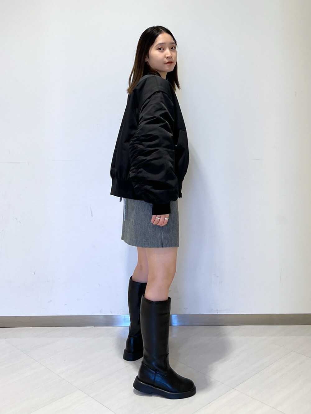 ブラック系のMA-1、ブルー系のニット/セーター、ブラック系のスカートを着用したレディースの冬コーディネートの4枚目の写真