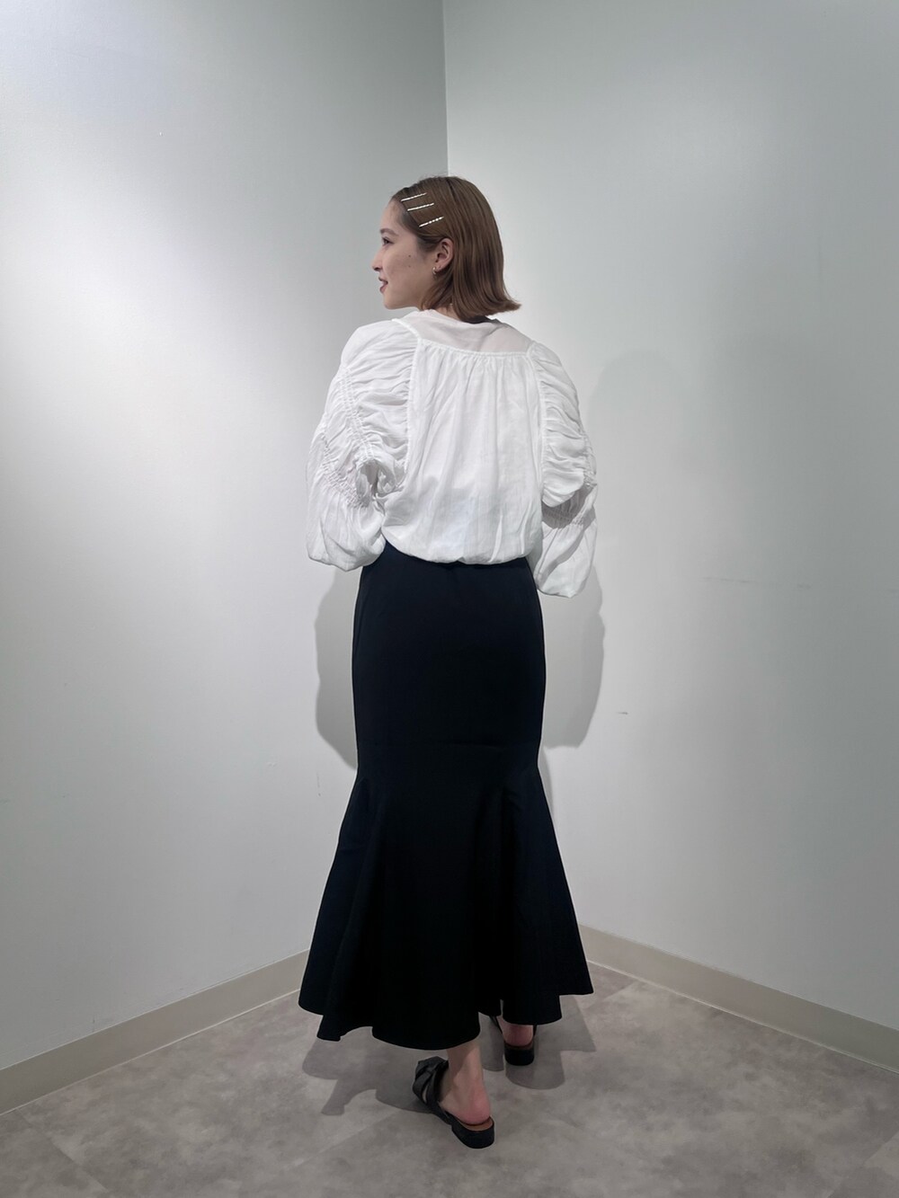 ブラック系のスカート、ホワイト系のカーディガン/ボレロ、ホワイト系のTシャツ/カットソーを着用したレディースの夏コーディネートの4枚目の写真