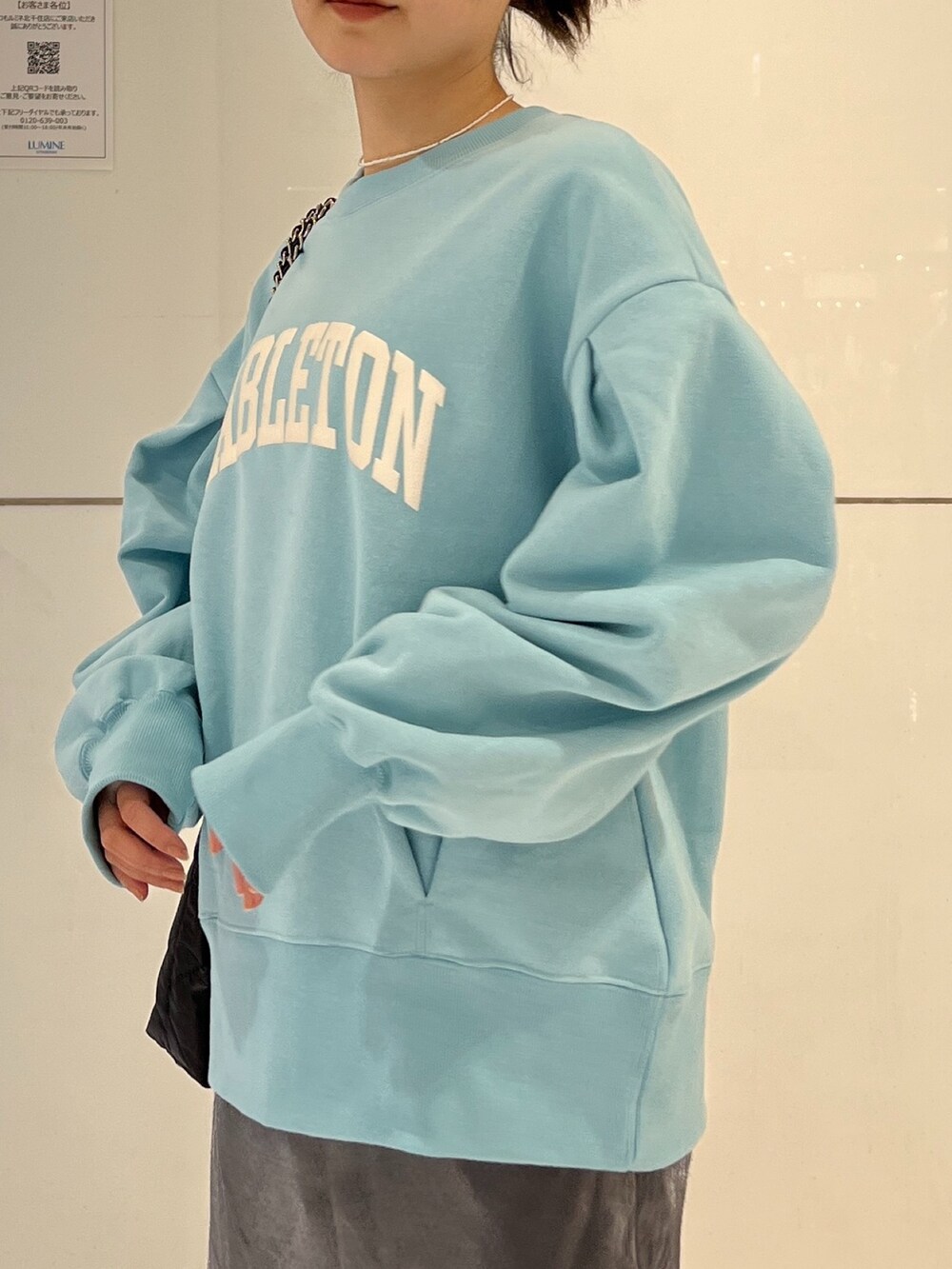 ブラック系のトートバッグ、ブラック系のスカート、ブルー系のスウェットを着用したレディースの冬コーディネートの6枚目の写真