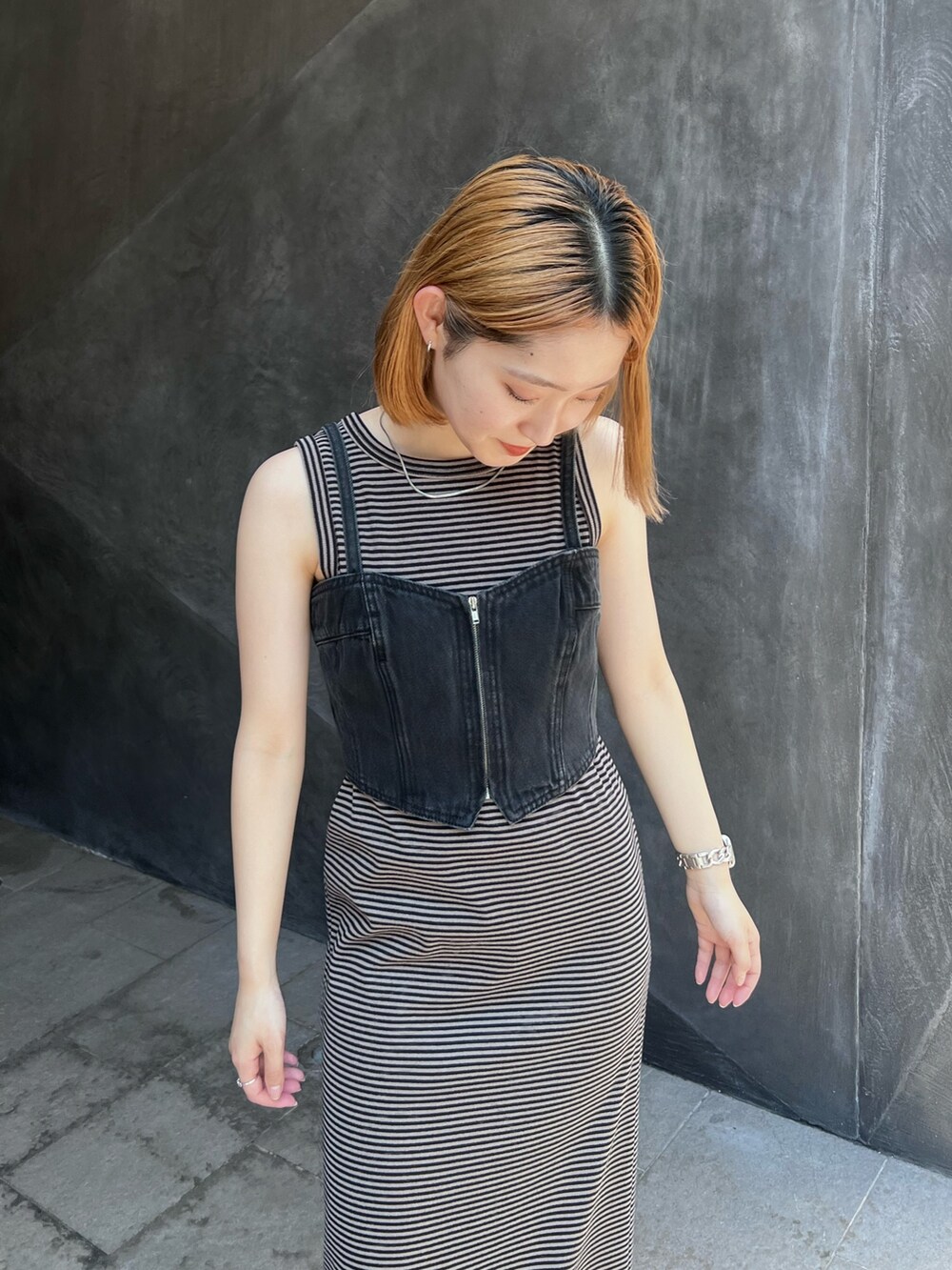 ブラウン系のワンピース、ブラック系のベスト、ブラック系のサンダルを着用したレディースの夏コーディネートの5枚目の写真