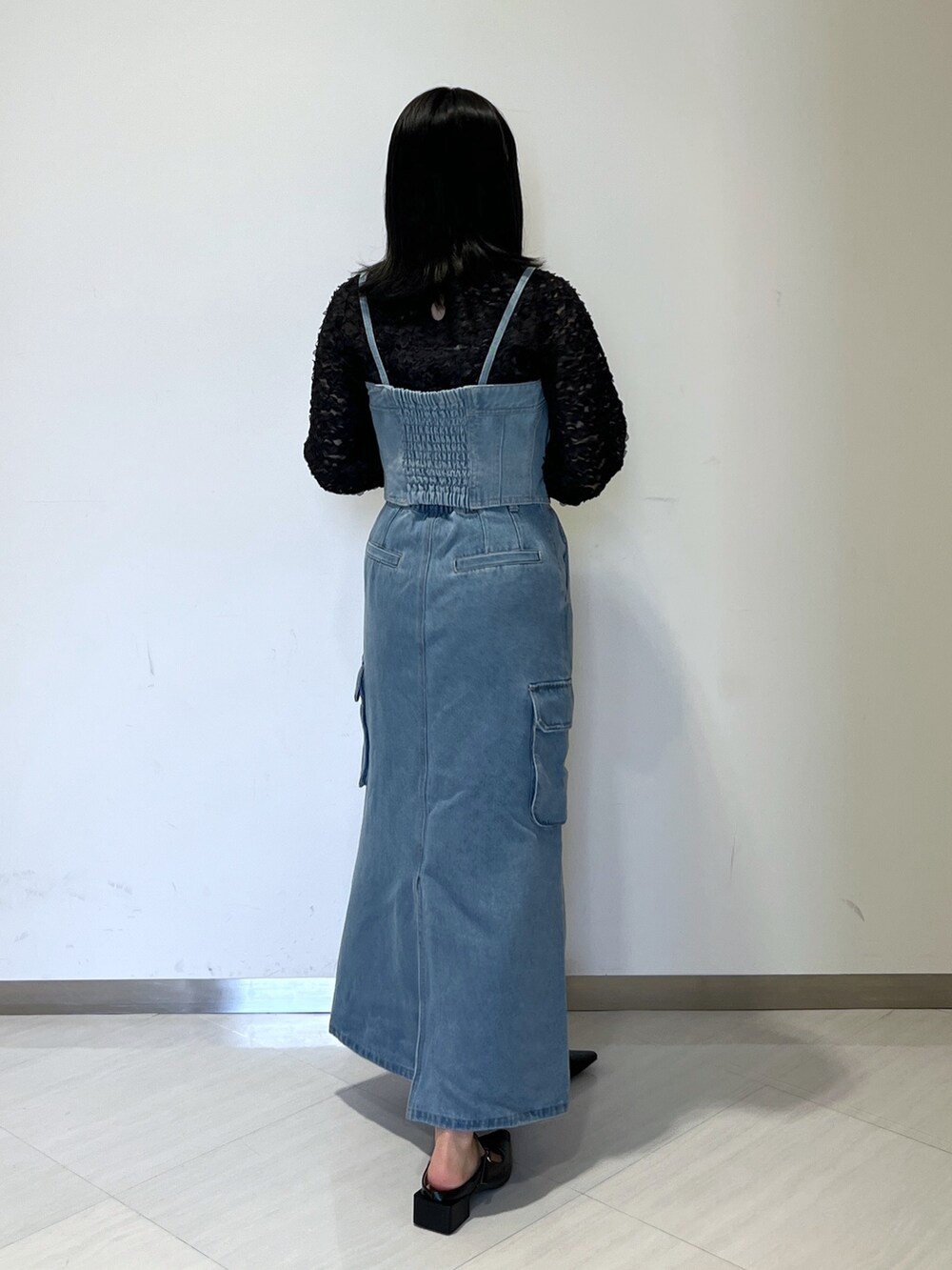 ブラック系のシャツ/ブラウス、ブルー系のベスト、ブルー系のデニムスカートを着用したレディースの冬コーディネートの5枚目の写真