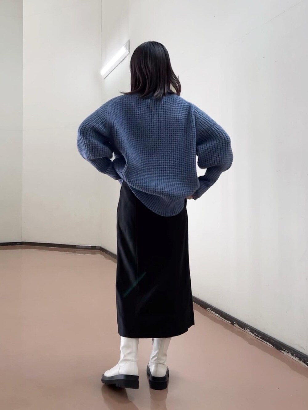 ブルー系のニット/セーター、ブラック系のスカート、ホワイト系のブーツを着用したレディースの秋コーディネートの4枚目の写真