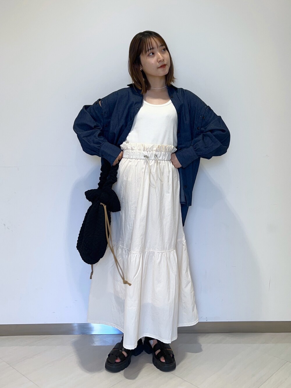 ホワイト系のタンクトップ、ブルー系のシャツ/ブラウス、ホワイト系のスカートを着用したレディースの秋コーディネートの5枚目の写真