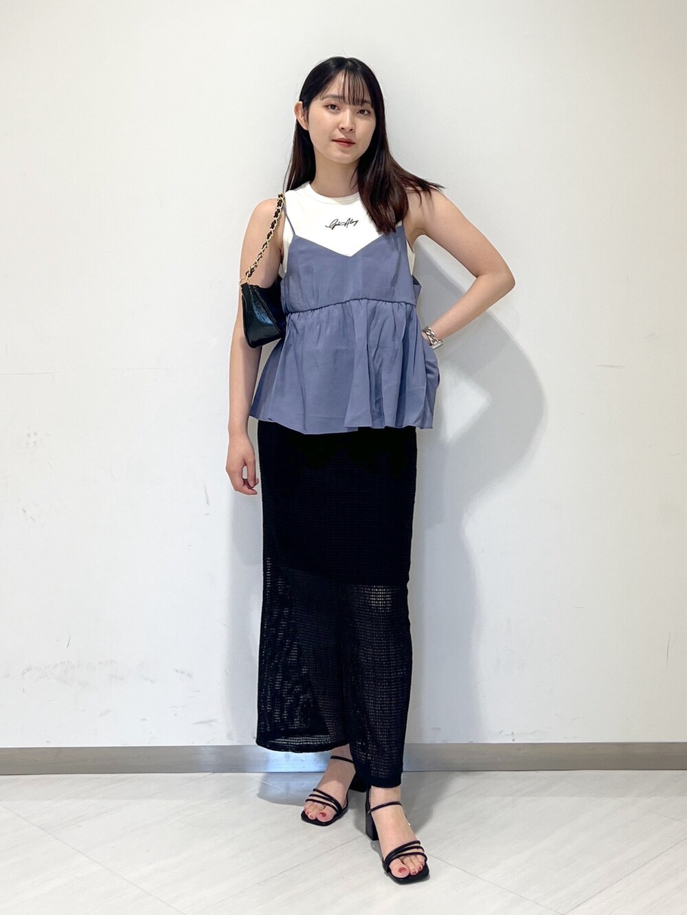 ホワイト系のタンクトップ、ブルー系のシャツ/ブラウス、ブラック系のトートバッグを着用したレディースの夏コーディネートの5枚目の写真