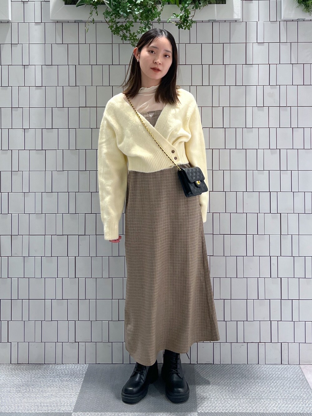 ホワイト系のニット/セーター、ホワイト系のTシャツ/カットソー、ブラウン系のワンピースを着用したレディースの冬コーディネートの2枚目の写真