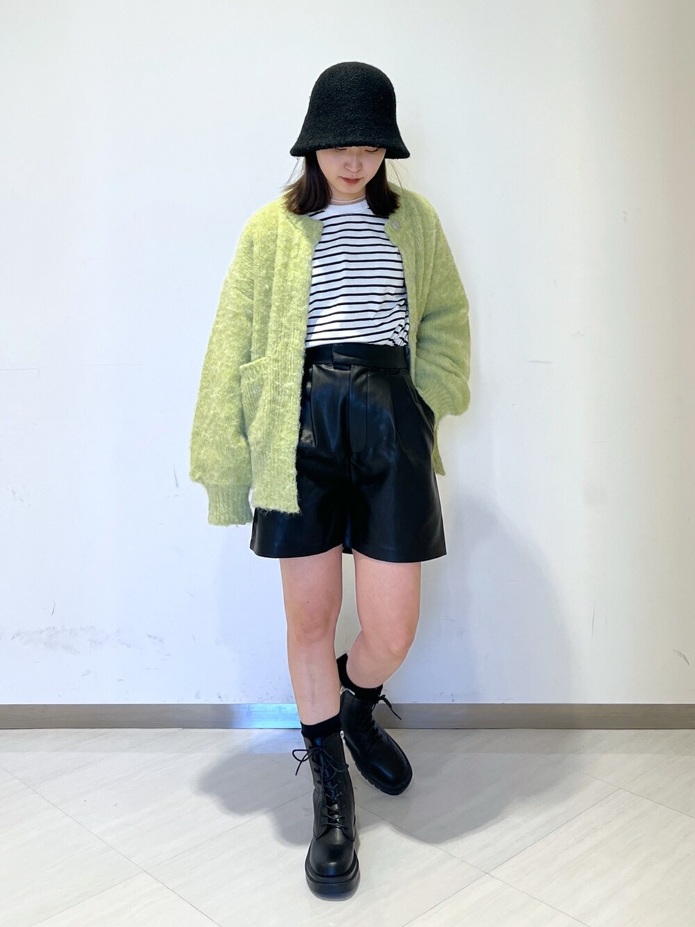 ブラック系のTシャツ/カットソー、グリーン系のニット/セーター、ブラック系のその他パンツを着用したレディースの冬コーディネートの4枚目の写真