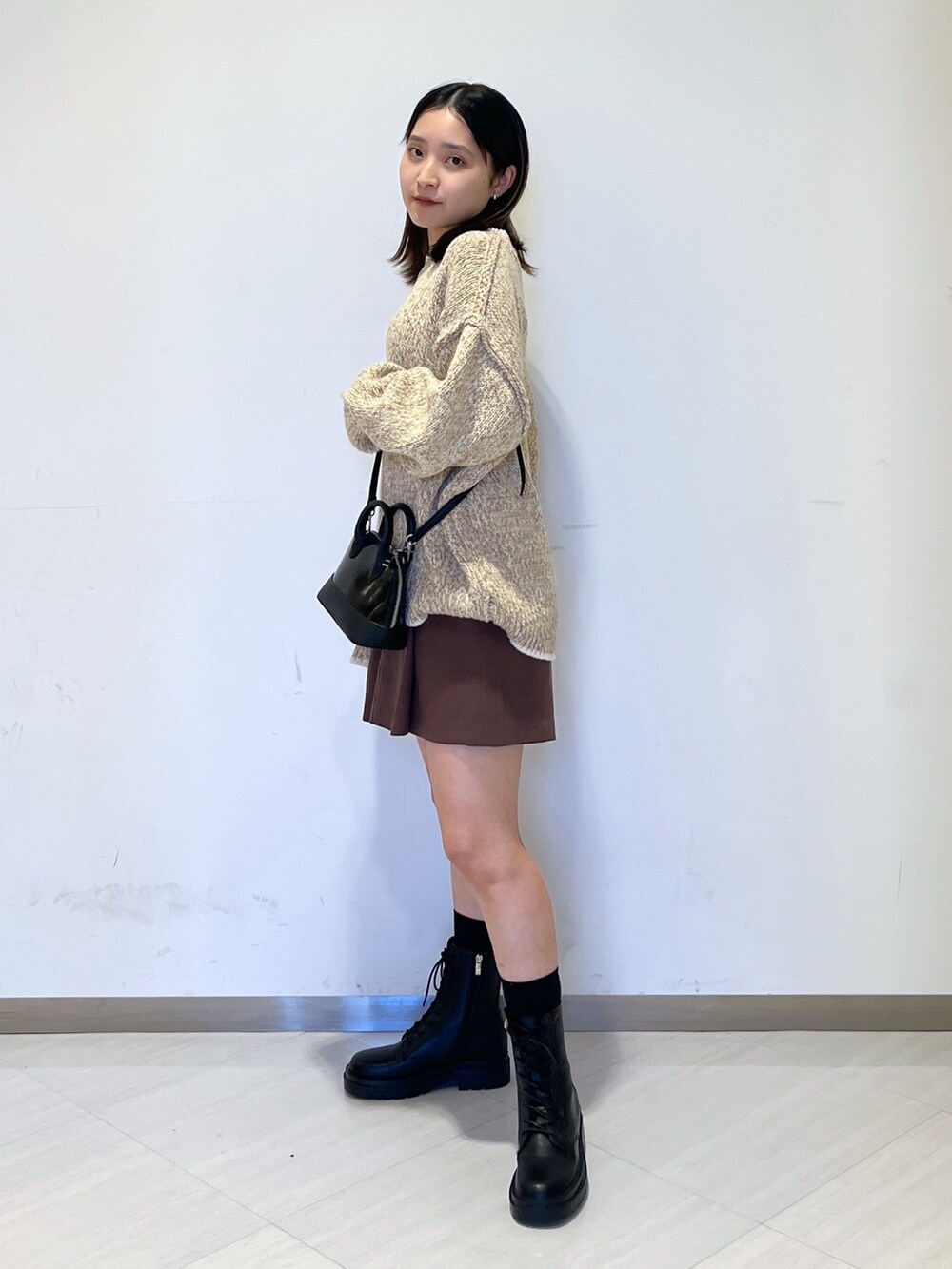 ベージュ系のニット/セーター、ブラック系のショルダーバッグ、ブラウン系のその他パンツを着用したレディースの冬コーディネートの4枚目の写真