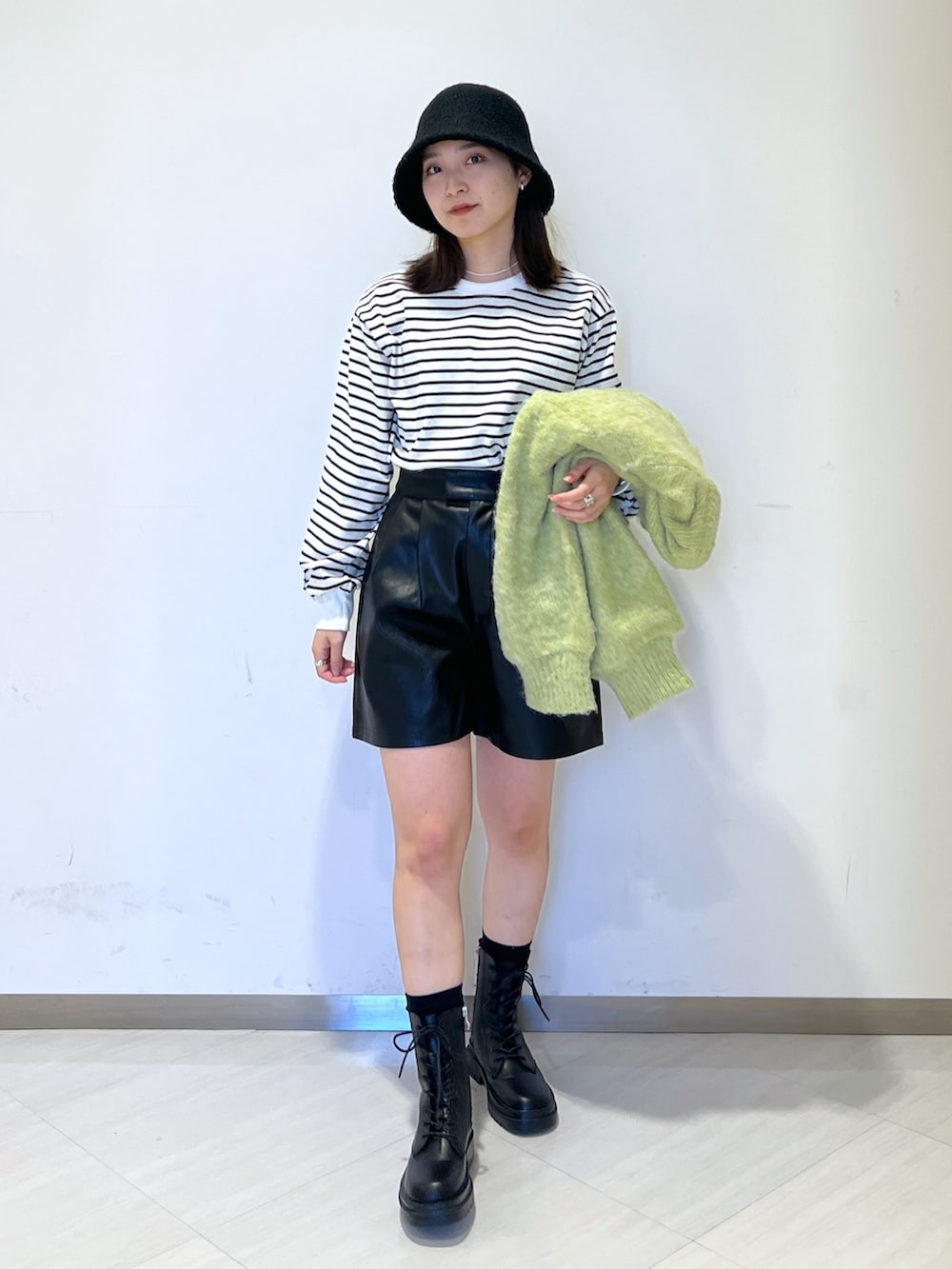 ブラック系のTシャツ/カットソー、グリーン系のニット/セーター、ブラック系のその他パンツを着用したレディースの冬コーディネートの2枚目の写真