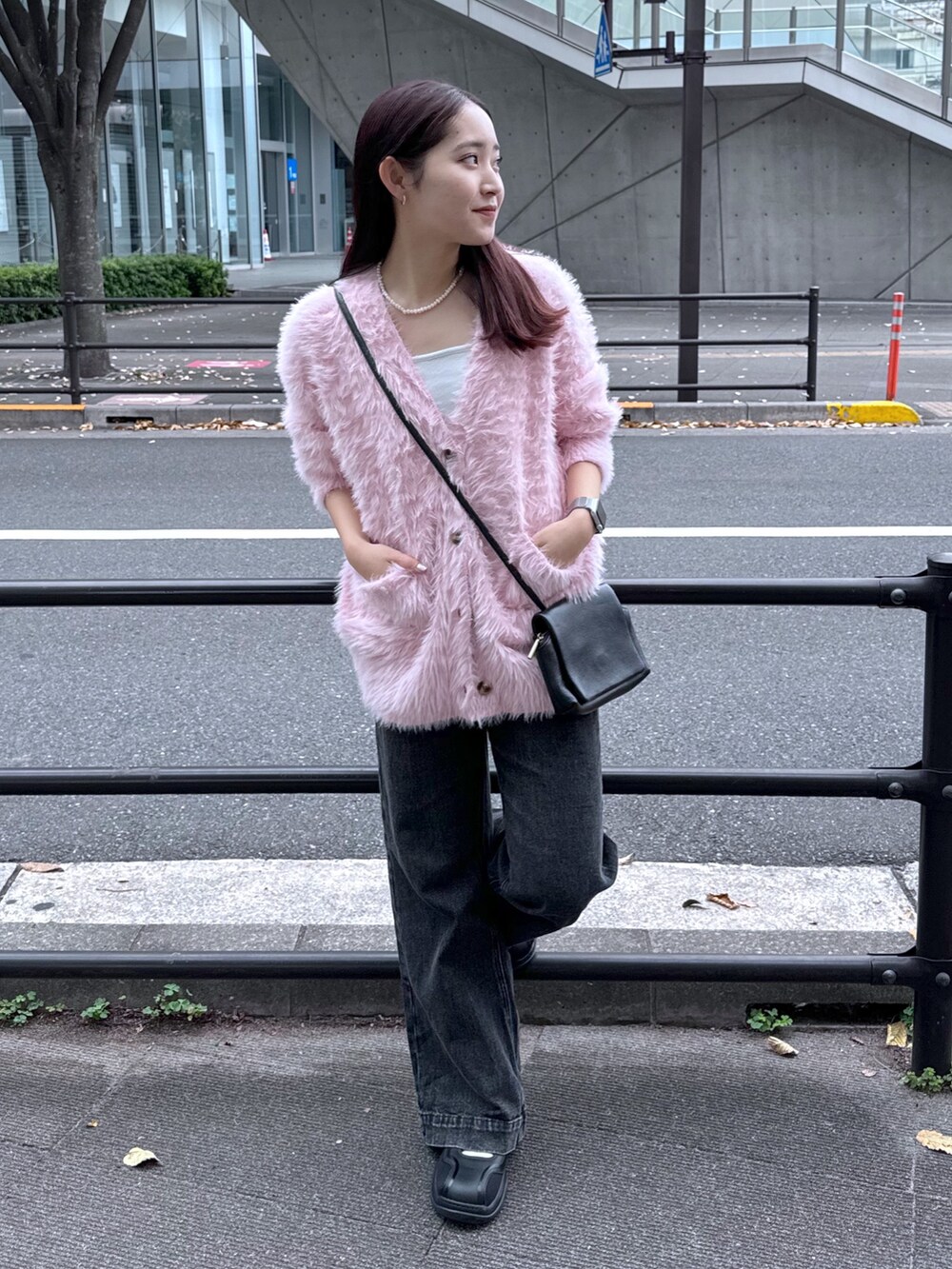 ブラック系のデニムパンツ、ピンク系のカーディガン/ボレロ、ホワイト系のキャミソールを着用したレディースの秋コーディネートの5枚目の写真