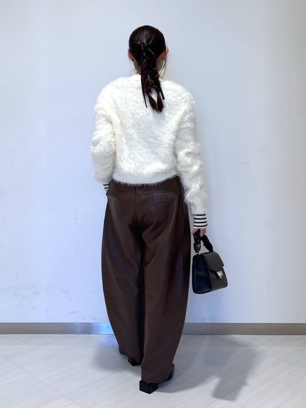 ホワイト系のニット/セーター、ホワイト系のカーディガン/ボレロ、ブラウン系のその他パンツを着用したレディースの秋コーディネートの4枚目の写真