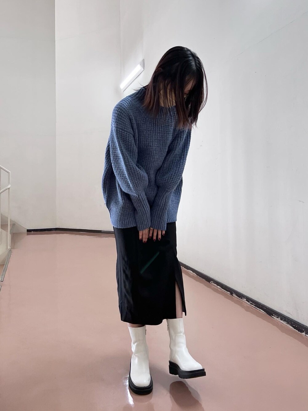 ブルー系のニット/セーター、ブラック系のスカート、ホワイト系のブーツを着用したレディースの秋コーディネートの3枚目の写真