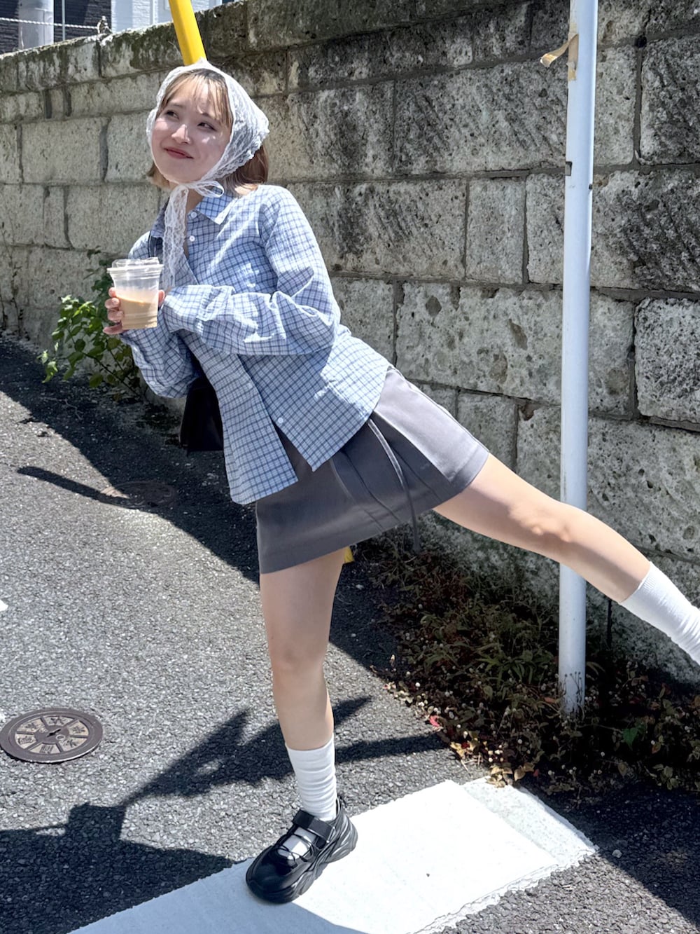 ブルー系のシャツ/ブラウス、グレー系のスカート、ブラック系のスニーカーを着用したレディースの夏コーディネートの2枚目の写真