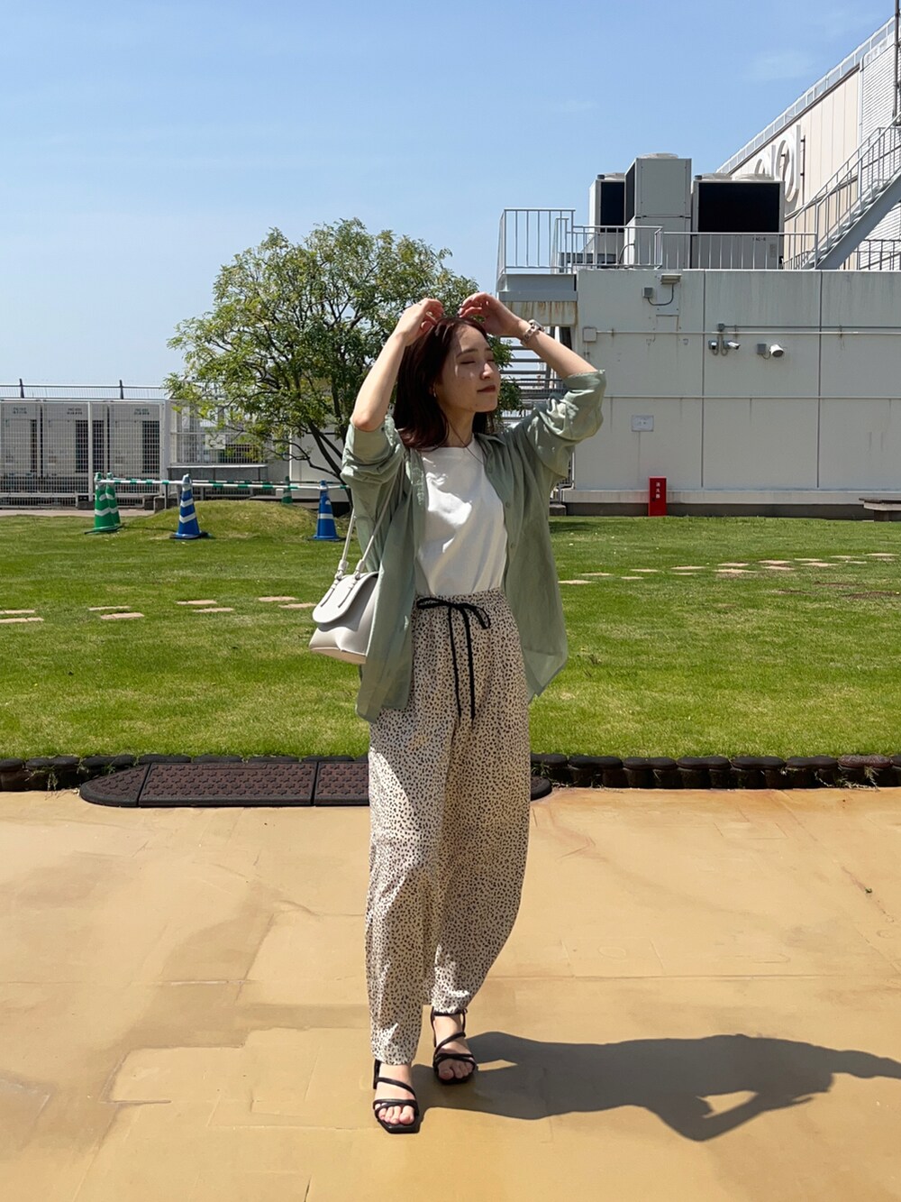 ブラック系のサンダル、ホワイト系のその他パンツ、グリーン系のシャツ/ブラウスを着用したレディースの春コーディネートの2枚目の写真