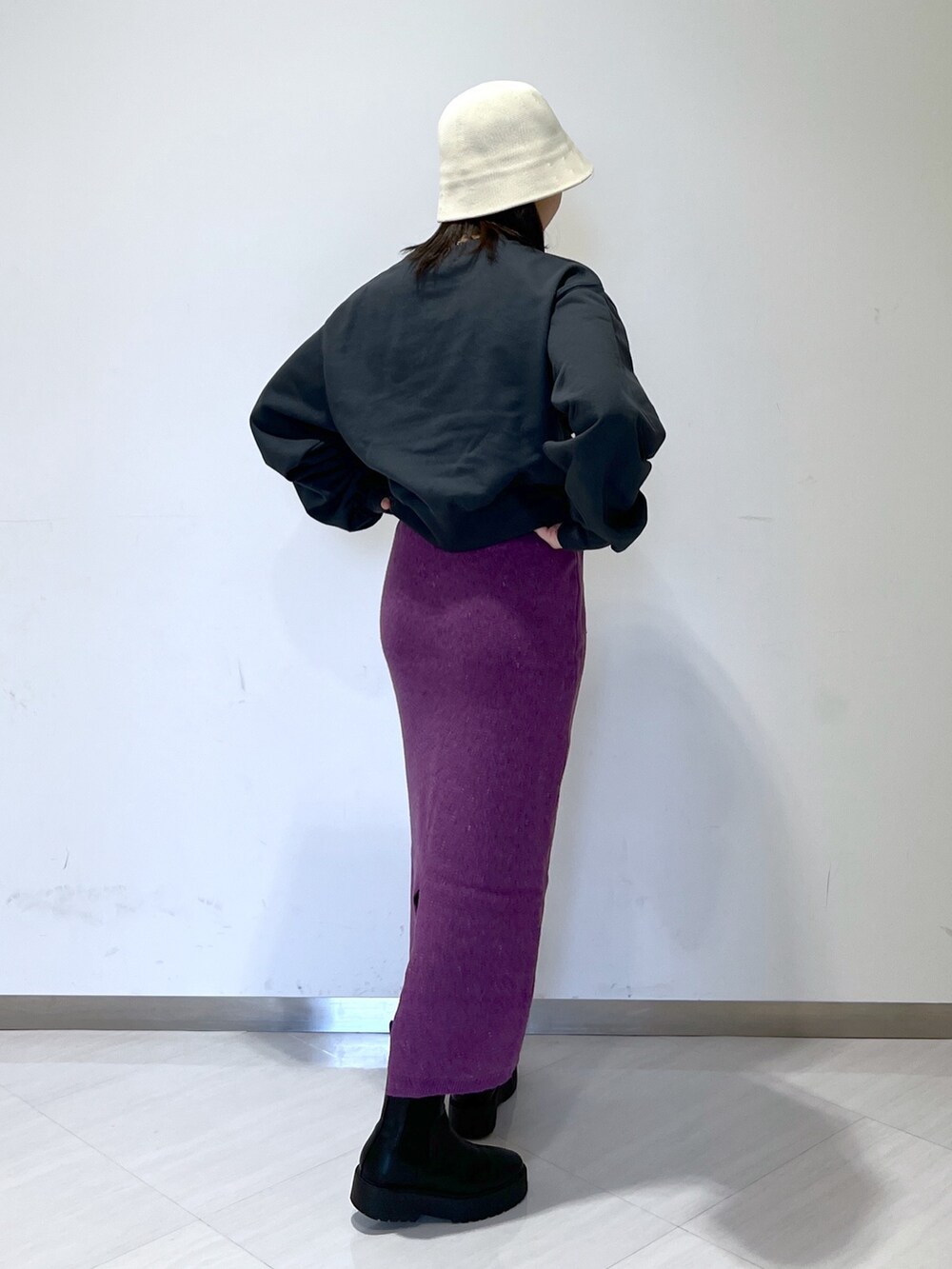 ブラック系のスウェット、パープル系のスカート、ベージュ系のハットを着用したレディースの冬コーディネートの4枚目の写真