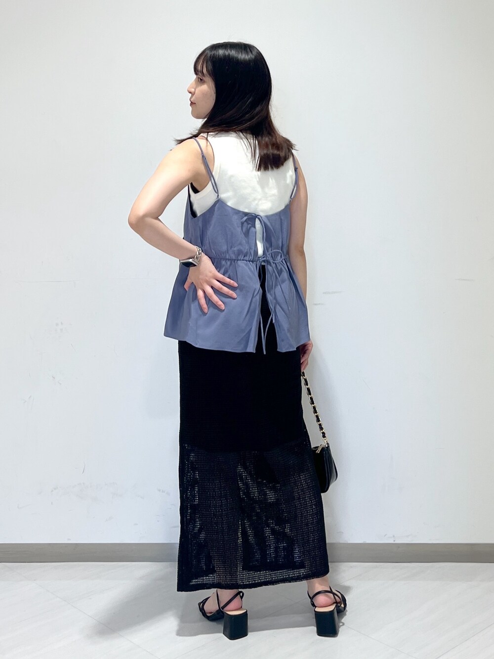 ホワイト系のタンクトップ、ブルー系のシャツ/ブラウス、ブラック系のトートバッグを着用したレディースの夏コーディネートの4枚目の写真