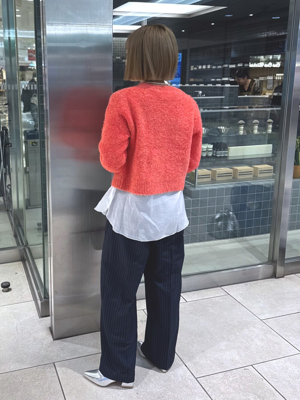 ホワイト系のTシャツ/カットソー、ピンク系のカーディガン/ボレロ、ブルー系のスラックスを着用したレディースの冬コーディネートの5枚目の写真