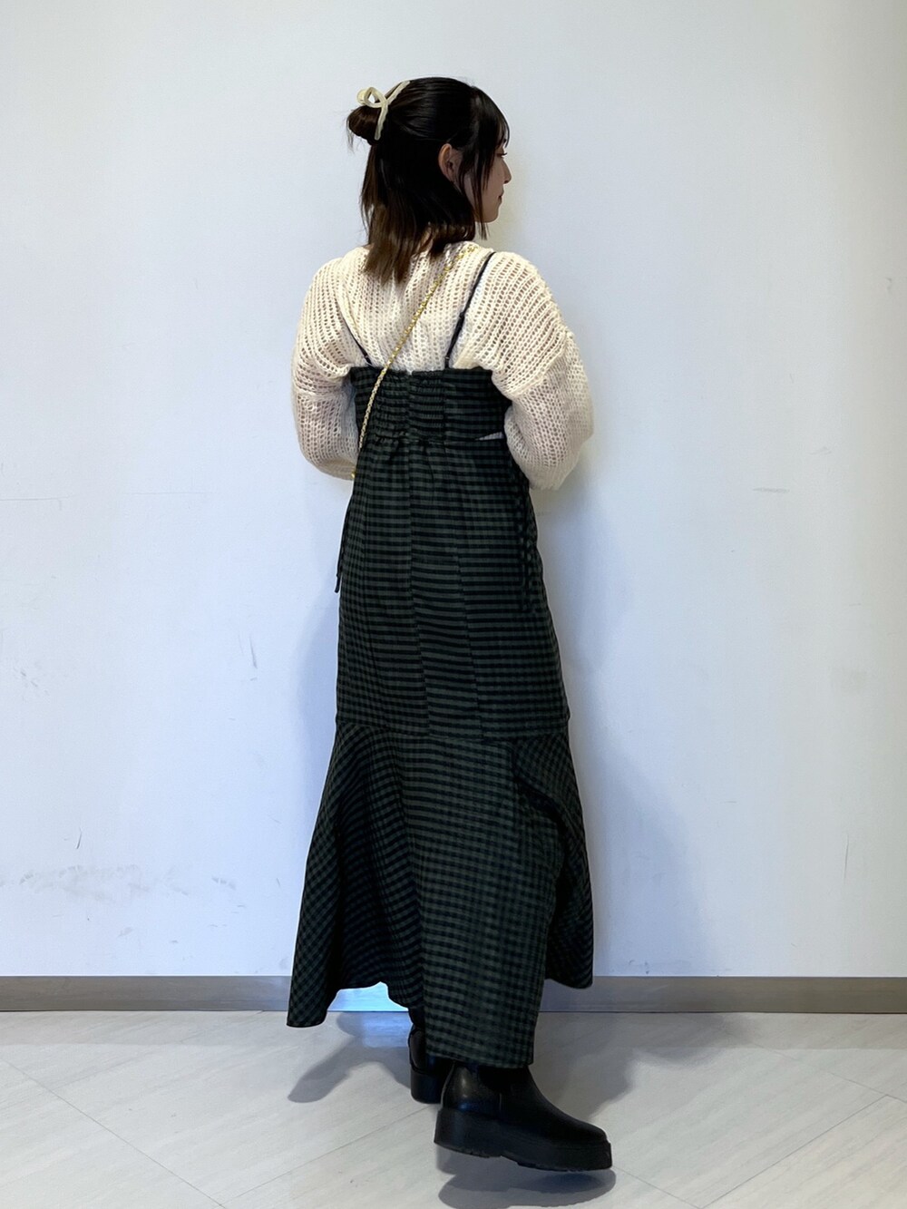 グリーン系のワンピース、ホワイト系のショルダーバッグ、ホワイト系のニット/セーターを着用したレディースの冬コーディネートの3枚目の写真