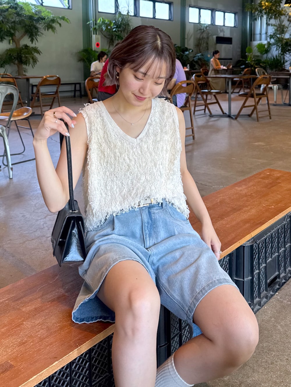 ホワイト系のニット/セーター、ブルー系のデニムパンツ、ベージュ系のローファーを着用したレディースの夏コーディネートの2枚目の写真