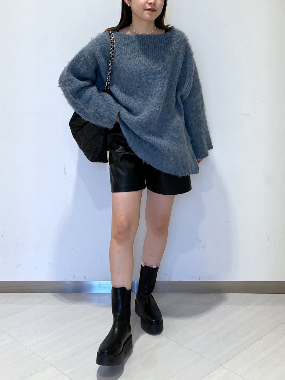 ブルー系のニット/セーター、ブラック系のトートバッグ、ブラック系のその他パンツを着用したレディースの冬コーディネートの3枚目の写真