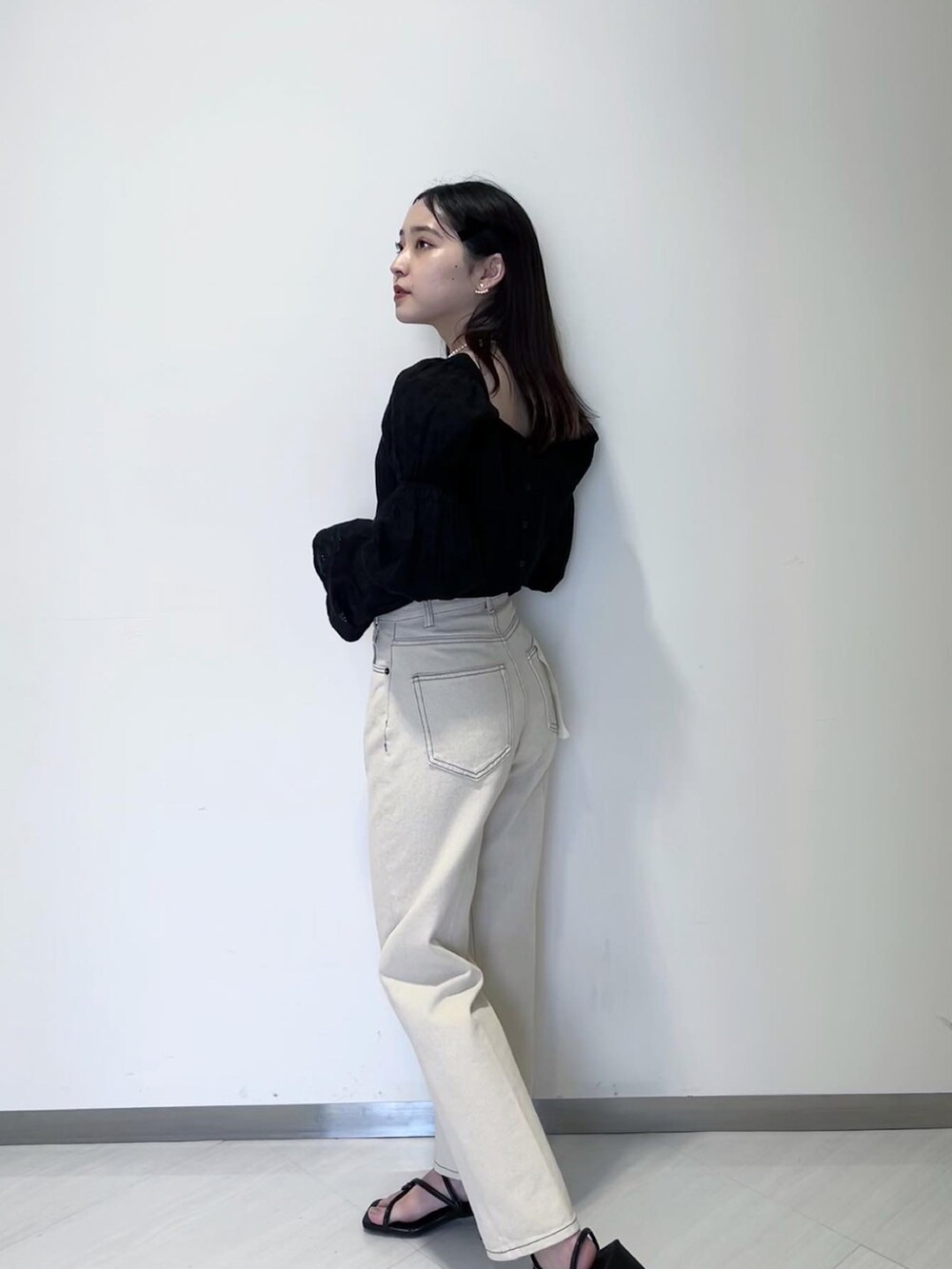 ブラック系のニット/セーター、ブラック系のカーディガン/ボレロ、ホワイト系のデニムパンツを着用したレディースの春コーディネートの3枚目の写真