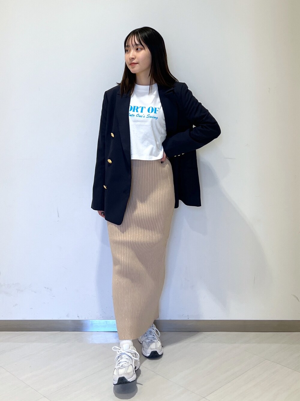 ホワイト系のTシャツ/カットソー、ブルー系のテーラードジャケット、ゴールド系のスカートを着用したレディースの冬コーディネートの2枚目の写真