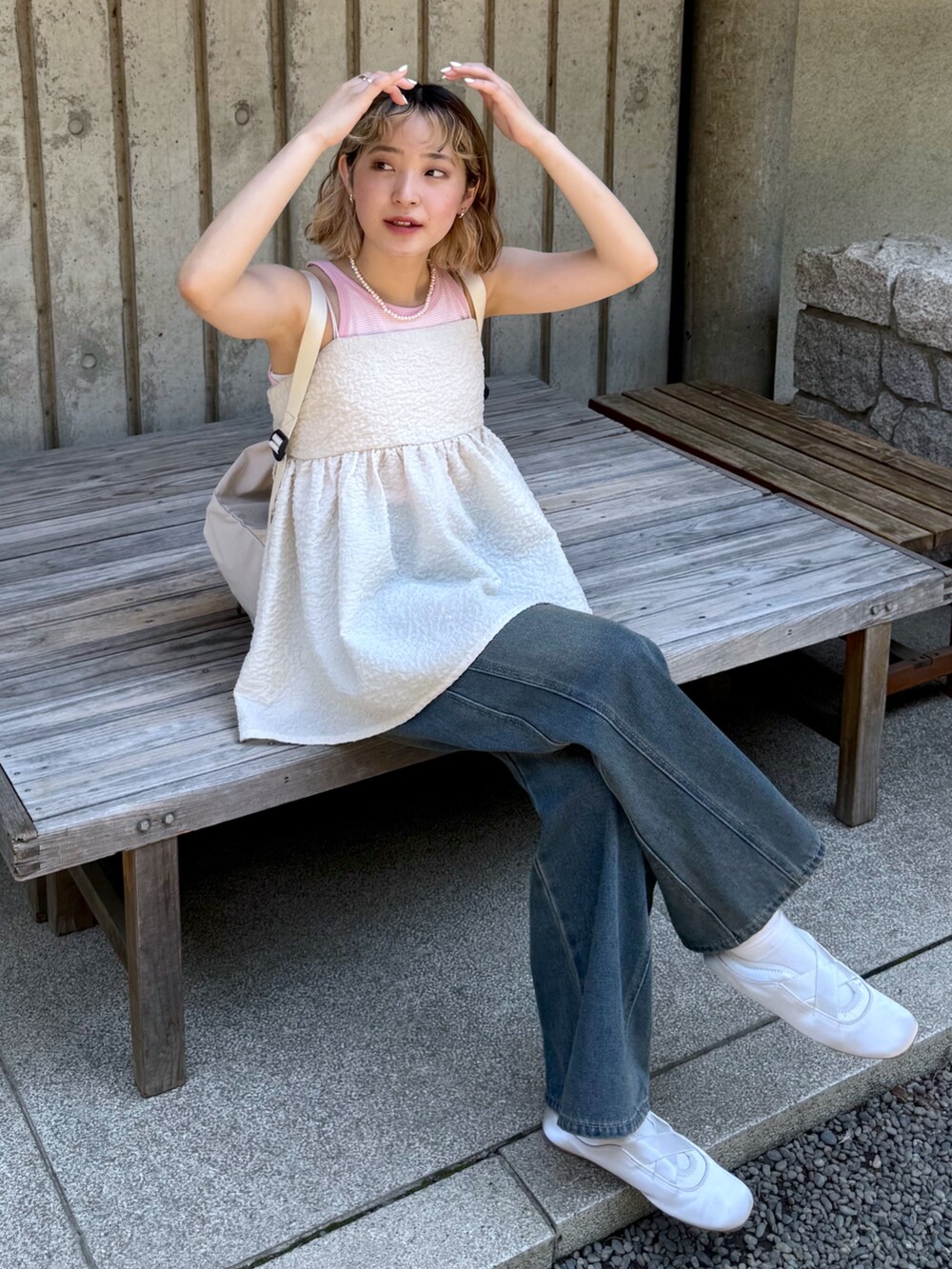 ピンク系のタンクトップ、ホワイト系のキャミソール、ブルー系のデニムパンツを着用したレディースの夏コーディネートの3枚目の写真