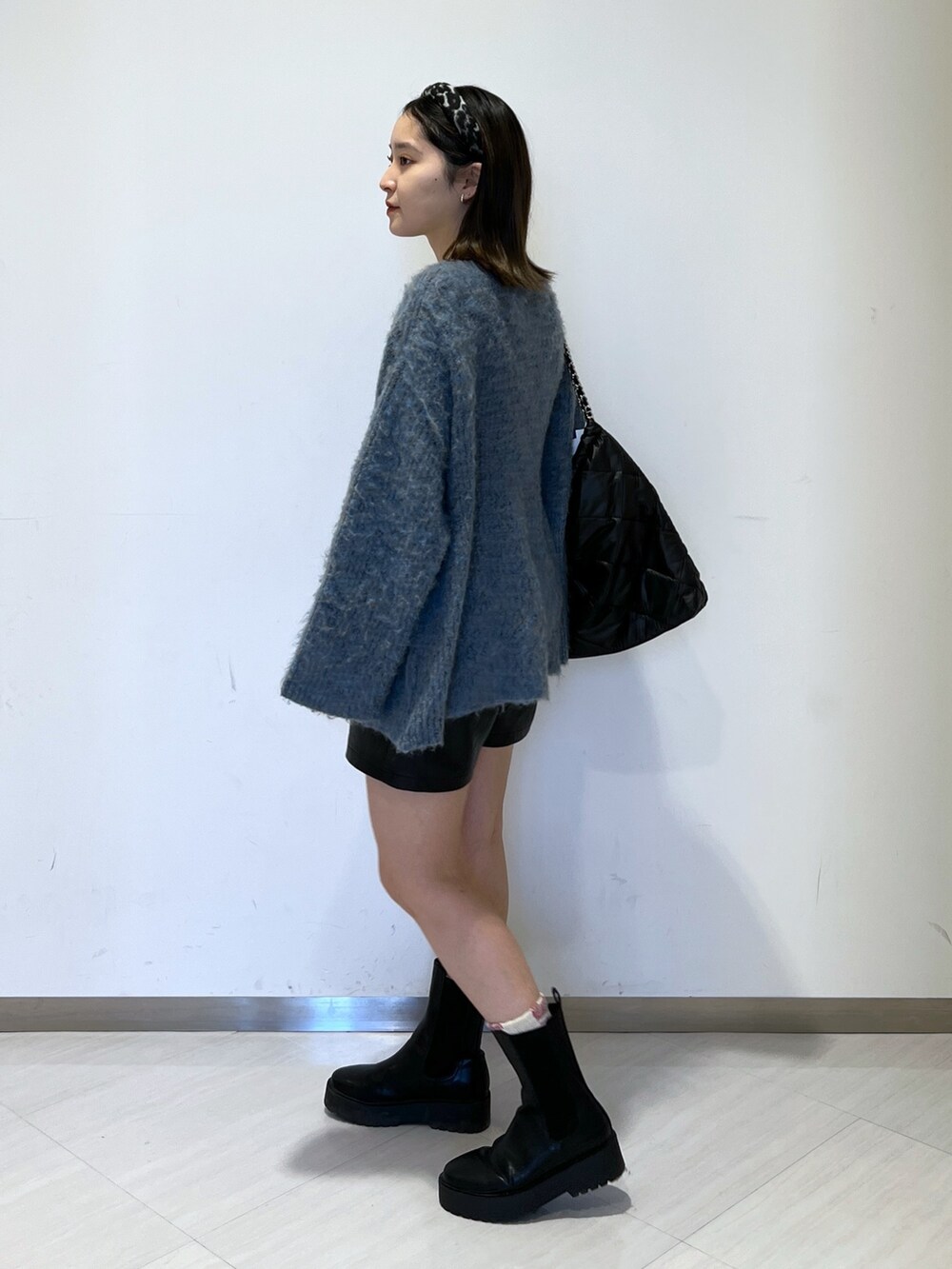 ブルー系のニット/セーター、ブラック系のトートバッグ、ブラック系のその他パンツを着用したレディースの冬コーディネートの4枚目の写真