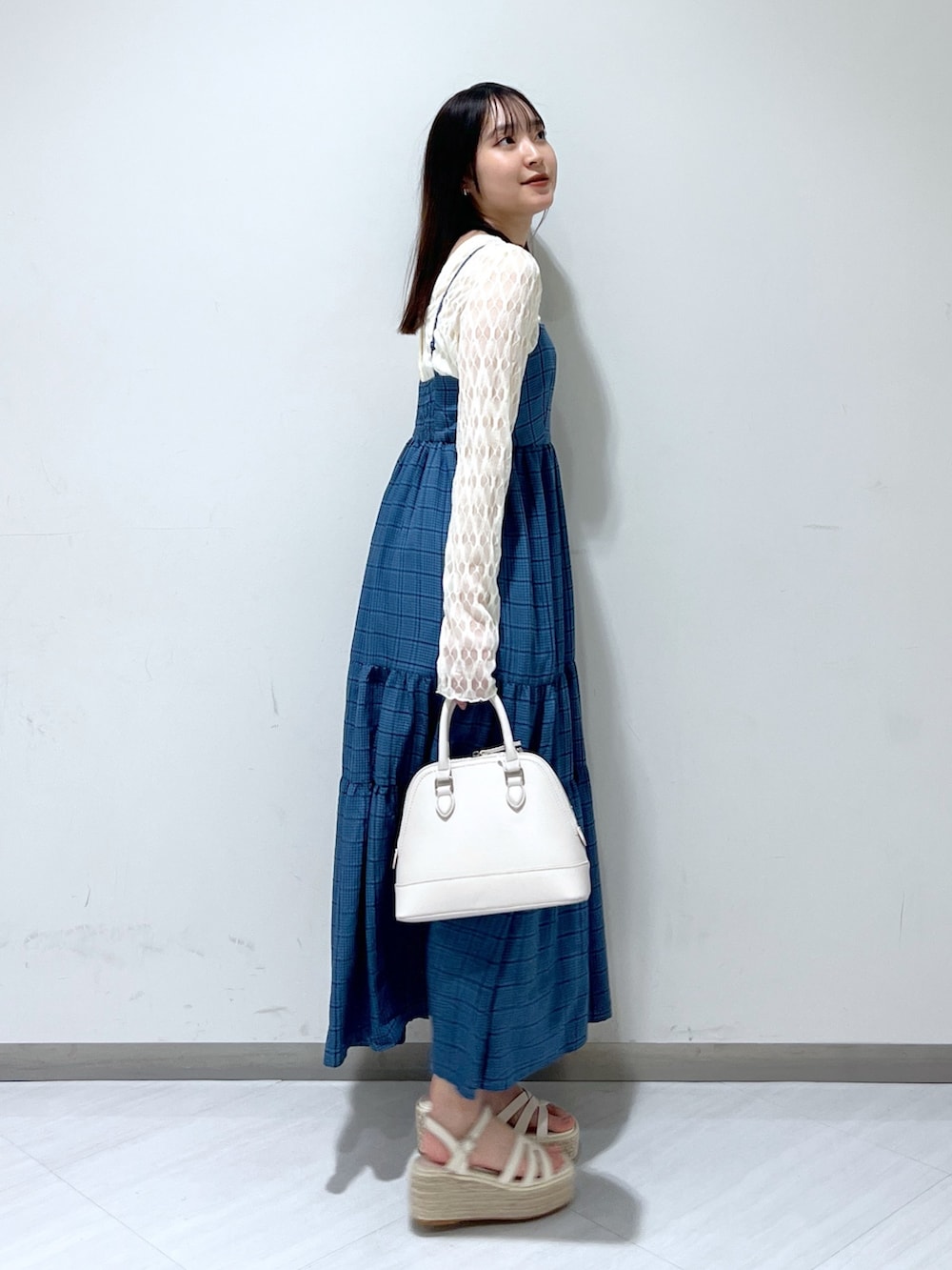 ホワイト系のショルダーバッグ、ブルー系のワンピース、ホワイト系のカーディガン/ボレロを着用したレディースの春コーディネートの3枚目の写真