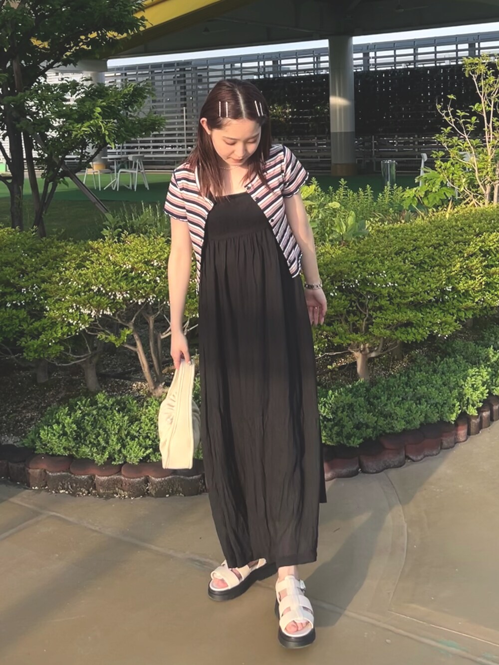 ホワイト系のトートバッグ、ブルー系のTシャツ/カットソー、ブラック系のワンピースを着用したレディースの春コーディネートの4枚目の写真