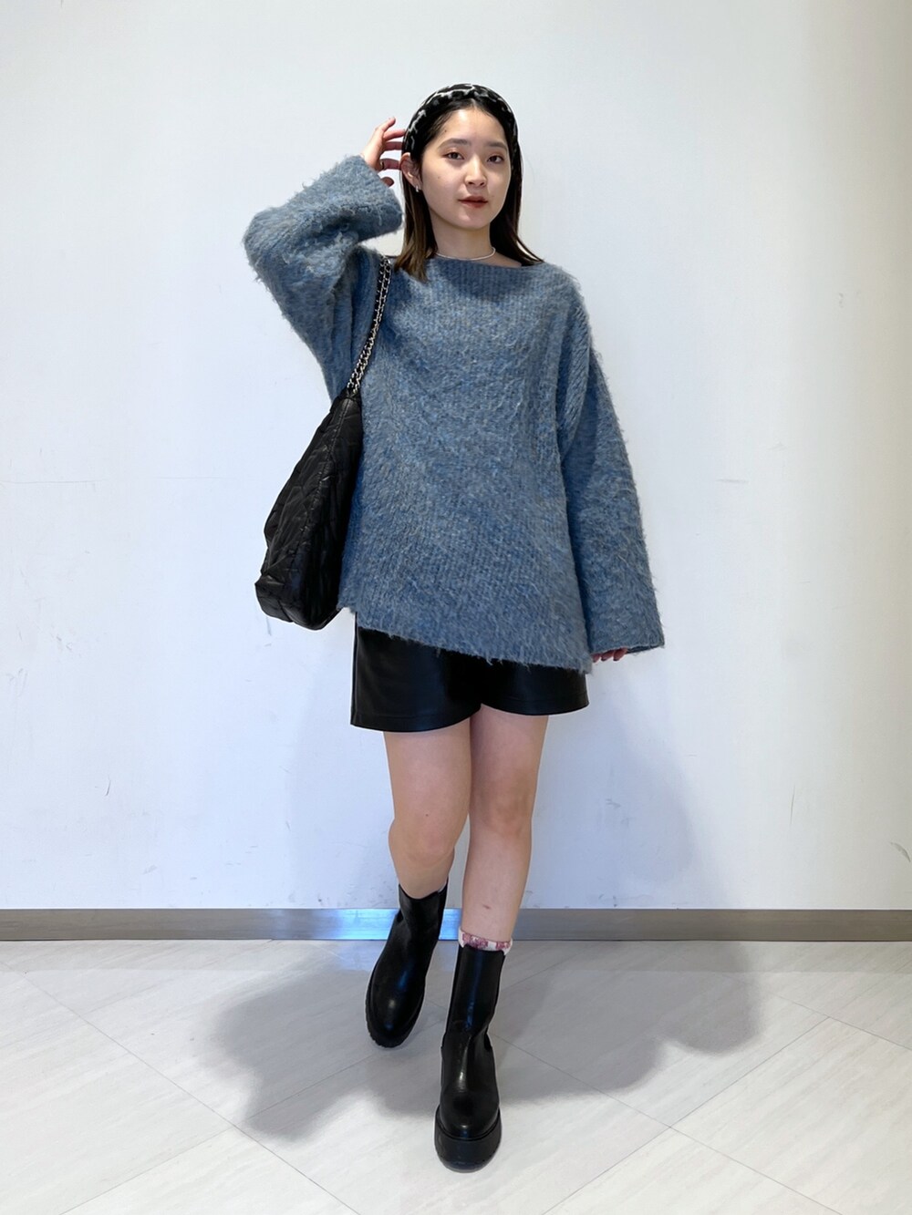 ブルー系のニット/セーター、ブラック系のトートバッグ、ブラック系のその他パンツを着用したレディースの冬コーディネートの2枚目の写真