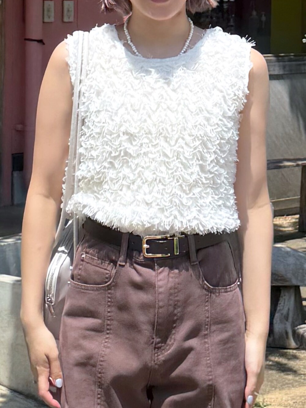 ホワイト系のシャツ/ブラウス、ブラウン系のデニムパンツ、ブラック系のスニーカーを着用したレディースの夏コーディネートの3枚目の写真