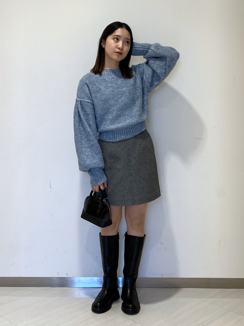 ブラック系のMA-1、ブルー系のニット/セーター、ブラック系のスカートを着用したレディースの冬コーディネートの5枚目の写真