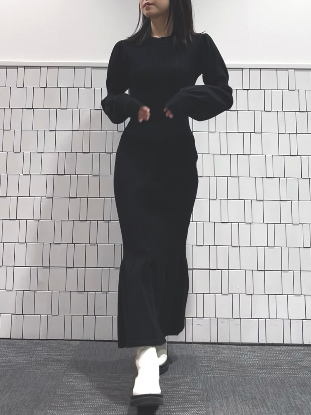 イエロー系のテーラードジャケット、ブラック系のワンピース、ホワイト系のブーツを着用したレディースの冬コーディネートの4枚目の写真