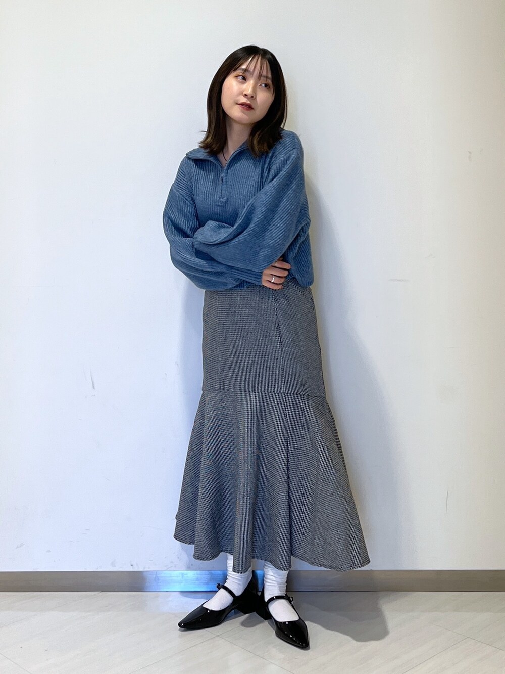 ブルー系のワンピース、ブラック系のスカート、ブラック系のバレエシューズを着用したレディースの冬コーディネートの3枚目の写真