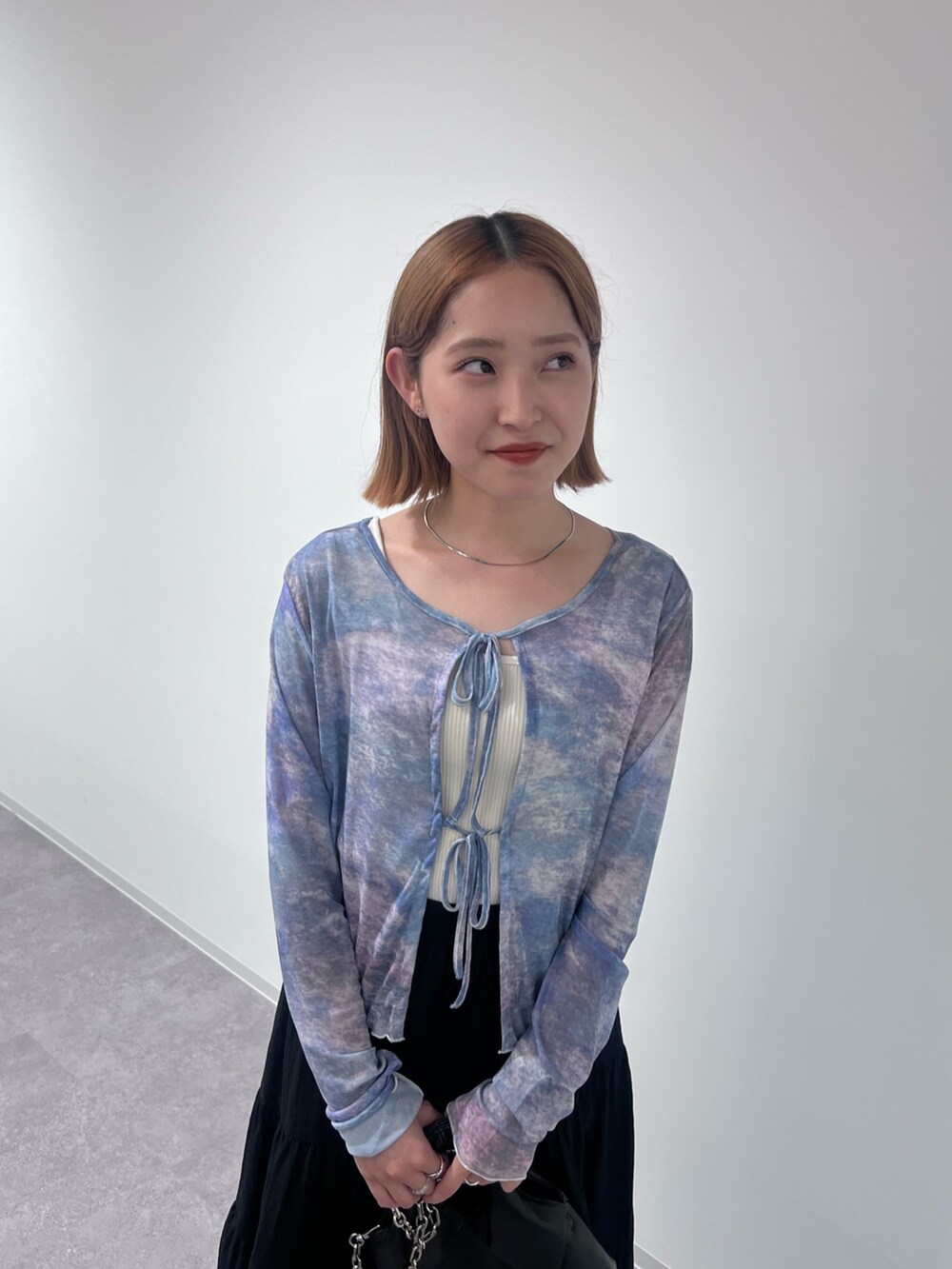 ブラック系のトートバッグ、ブラック系のスカート、ブラック系のサンダルを着用したレディースの夏コーディネートの5枚目の写真